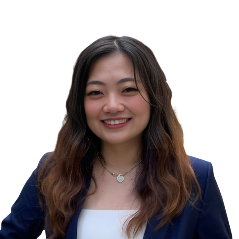A woman with long wavy hair, wearing a navy blazer over a white top and a necklace, smiles at the camera against a white background—reflecting the professional poise of PreceptsGroup Staff estate planning practitioners.